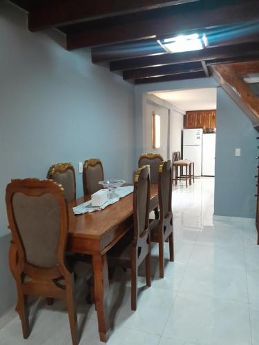 a dining room with a wooden table and chairs at Apart hotel GAVA in Encarnación