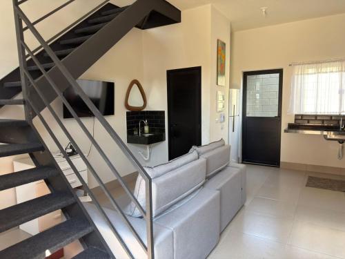 a living room with a couch and a staircase at Loft 02 - Alvares machado in Álvares Machado