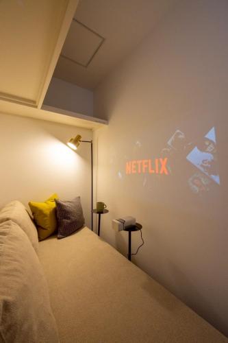 a bedroom with a bed with a netflix sign on the wall at jeje asahikawa in Asahikawa