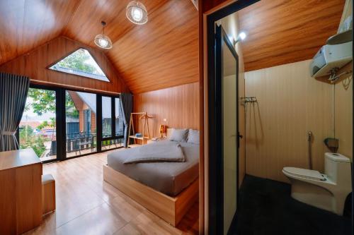 a bedroom with a bed and a bathroom with a window at Cat Ba Spring Homestay in Cat Ba