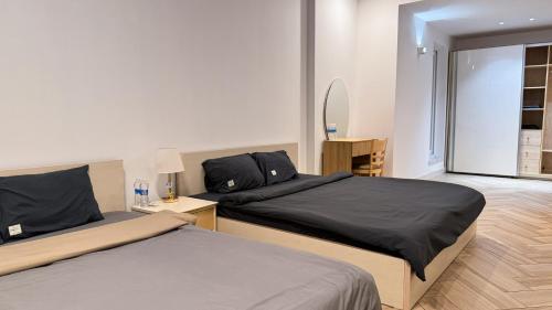 a bedroom with two beds and a mirror at The LH Homestay in Phú Quốc