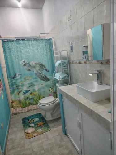 a bathroom with a dolphin shower curtain and a sink at Arcadia 1 in Santiago