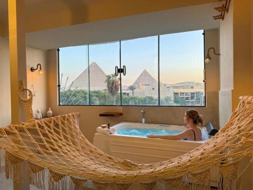 a woman in a hammock in a bathroom with pyramids at nirvana pyramids view in Cairo