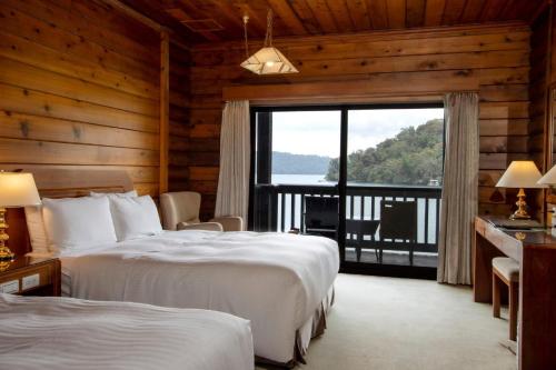 a hotel room with two beds and a balcony at LeaLea Garden Hotel Sun Moon Lake in Yuchi