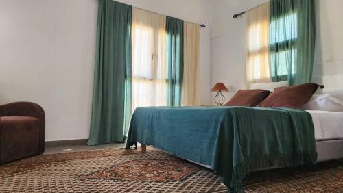 a bedroom with a bed with a green blanket on it at Suñu Tool Private Farm Guesthouse in Sindia