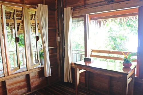 a room with a bench and windows in a wooden house at Phi Phi Phu Chalet Resort in Phi Phi Don