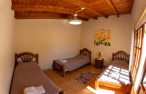 two beds in a room with wooden ceilings at Cabaña Piedra y Sol de CACHI in Cachí