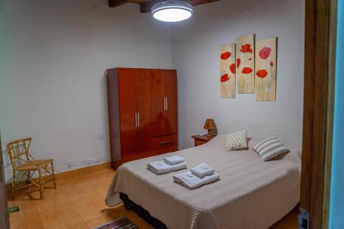 a bedroom with a bed with two towels on it at Cabaña Piedra y Sol de CACHI in Cachí