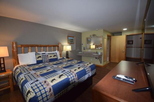 a bedroom with a bed and a desk with a remote control at Nisqually Lodge in Ashford