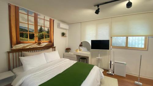 a bedroom with a bed and a desk with a television at YuYu stay in Seoul