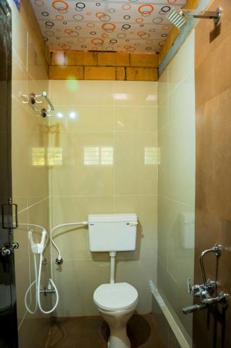 a small bathroom with a toilet and a shower at Lovelynest homestay in Attigundi