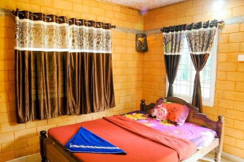a bedroom with a bed and a window with curtains at Lovelynest homestay in Attigundi