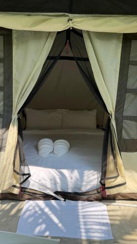a bed in a tent with two white pillows at Oasis2 Phuket Airport Glamping in Phuket