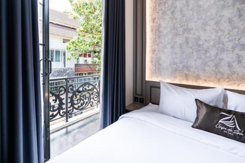 a bedroom with a bed and a large window at Casa De Zea by AKA in Yogyakarta