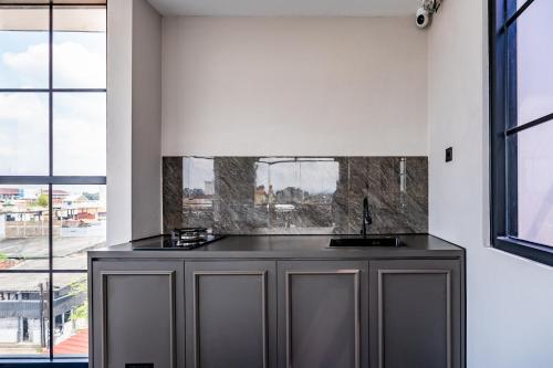 a kitchen with a counter in a room with windows at Casa De Zea by AKA in Yogyakarta