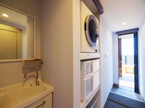 a bathroom with a sink and a washing machine at Private Ocean Resort YUUNAGI in Awaji