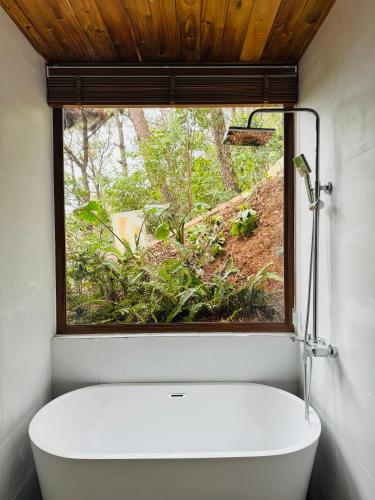 a bathroom with a window and a white tub at DeBay Retreat - Little Đà Lạt Chill Villa in Sóc Sơn