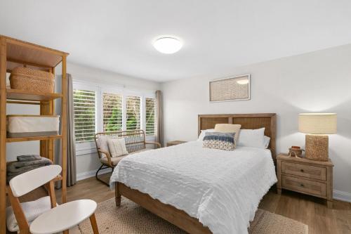 a bedroom with a bed and a chair at Blue View Gerringong in Gerringong