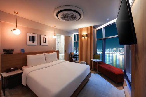 a bedroom with a large bed and a large window at Ocean 2Heaven Hotel Busan in Busan