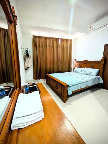 a bedroom with a bed and a table with towels at Mama Nusantara Hotel in Jertih