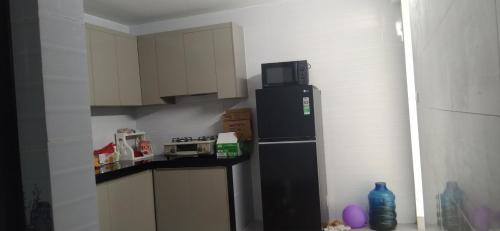 a kitchen with a black refrigerator and a microwave at Hotel Long Quân in Thanh Hóa