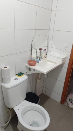 a bathroom with a white toilet and a sink at Apartamento Compacto Localização Privilegiada in Uberaba