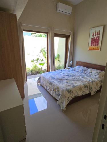 a bedroom with a bed and a large window at Laguna Ijen Homestay in Banyuwangi