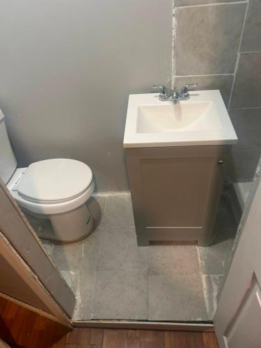 a bathroom with a toilet and a sink at Grove 4- Queen bed with Private bathroom in Irvington