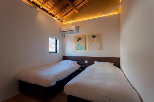 two beds in a small room withermottermottermottermott at Experience Ise Miyamachi Hotel in Ise