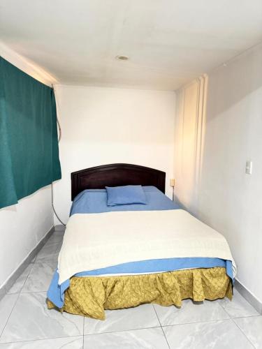 a bedroom with a large bed with blue and white sheets at Casa Gavril Escazu in San Antonio