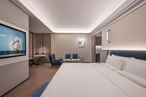 a hotel room with a large bed and a flat screen tv at Novotel Changshu Yushan in Changshu