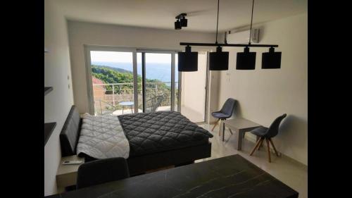 a bedroom with a bed and a large window at Apartman Triton in Ulcinj