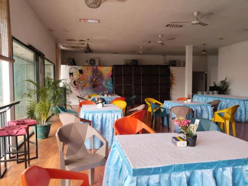 ein Raum mit Tischen und Stühlen mit blauen Tischdecken in der Unterkunft Mesirom B&B in Dili
