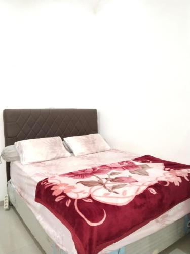 ein Bett mit einer rot-weißen Decke darauf in der Unterkunft Mesirom B&B in Dili