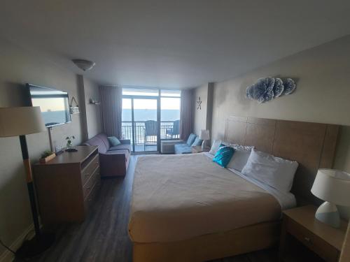 a hotel room with a bed and a view of the ocean at Ocean Front King Suit Myrtle Beach Heated Pools Landmark in Myrtle Beach