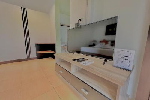 a living room with a large flat screen tv on a wall at The Shore Samui in Bangrak Beach