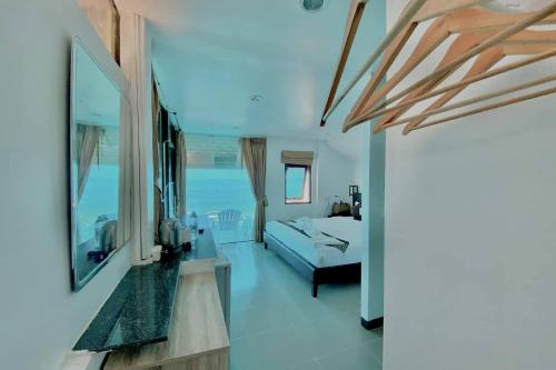 a living room with a bed and a view of the ocean at The Shore Samui in Bangrak Beach