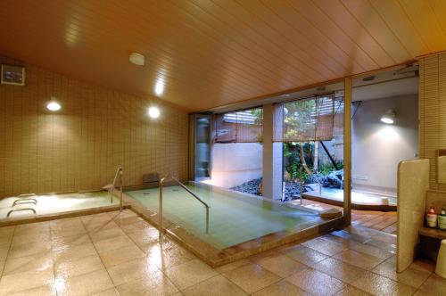 a room with a swimming pool in a house at Kanazawa Manten Hotel Ekimae in Kanazawa