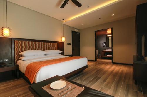 a hotel room with a large bed and a table at Two Seasons Coron Bayside Hotel in Coron