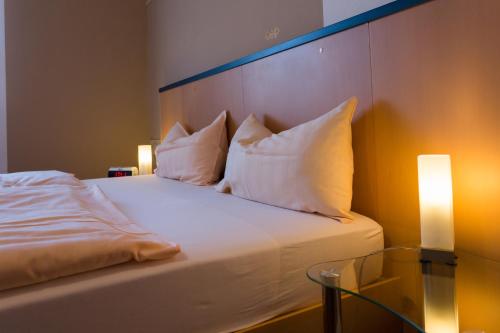 a bedroom with a bed with pillows and a glass table at Apartment Haus in Kleinblittersdorf