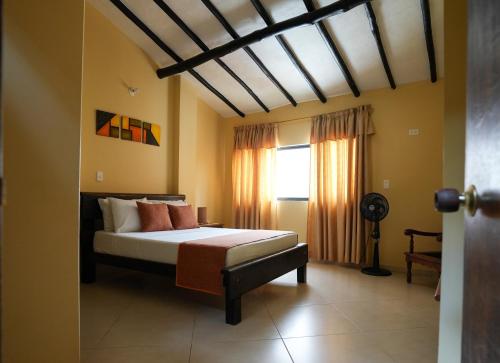 ein Schlafzimmer mit einem Bett und einem Fenster in der Unterkunft Macondo Hostel in San Gil