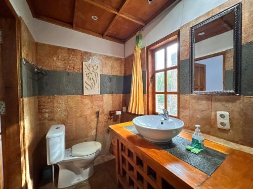 a bathroom with a sink and a toilet at Mangga Lodge in Bira