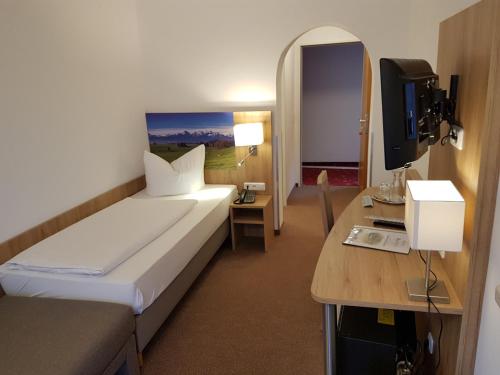 a hotel room with a bed and a television at Hotel Ruchti - Zeit für mich in Füssen