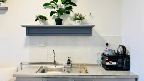 a kitchen counter with a sink and a microwave at Rainbow Paradise Seaview by Achlys Collection in Tanjung Bungah