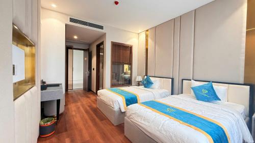 a hotel room with two beds and a television at Diamond Hotel Bỉm Sơn Thanh Hóa in Bỉm Sơn