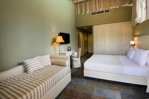 a bedroom with two beds and a couch at Le Ali Del Frassino in Peschiera del Garda