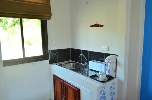 a small kitchen with a sink and a microwave at Phongpipat Lanta Mansion in Ko Lanta