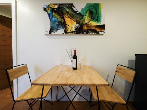 a table with two glasses of wine and a painting at 130 Hotel & Residence Bangkok in Bangkok