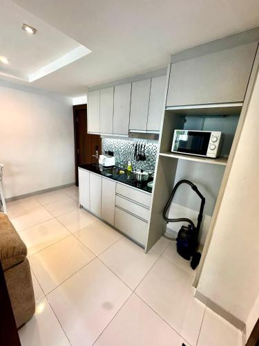 a small kitchen with a couch and a microwave at Apartment Serenity Wongamat in North Pattaya