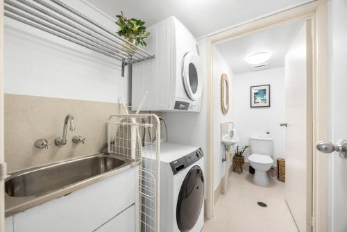 a small kitchen with a sink and a washing machine at Salad Days -Beachfront & Pet Friendly in Marcoola